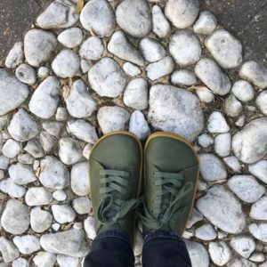 Photo of my feet in Vivo Barefoot Addis shoes standing on stones.