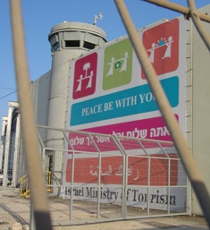 Outside of the Bethlehem wall with a poster saying: 'Peace be with you' by the Israeli tourism ministry.