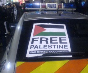 Photo of a Free Palestine poster affixed to a police car.