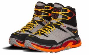 Image of a pair of Hoka Tor Ultra Hi hiking boots. They are grey and black with orange and yellow highlights.