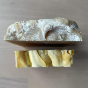Photo of two pieces of soap, one beige and one orange. View point is from the top.